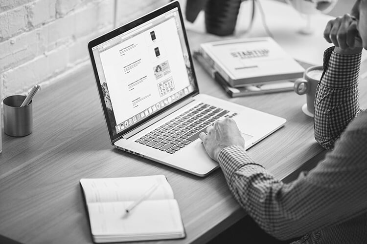 Black and white image of a man looking at a laptop screen